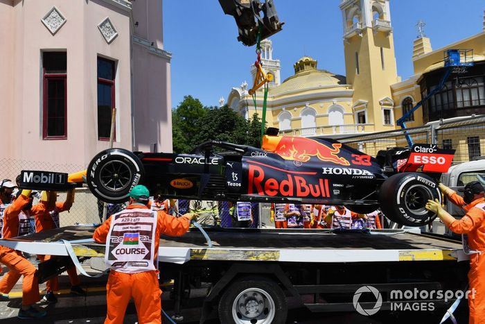 Los comisarios carga en coche dañado de Max Verstappen, Red Bull Racing RB16B, en una grúa