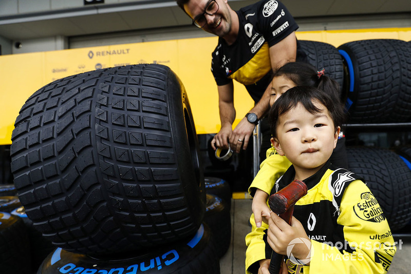 Young fans check out the Pirelli tyres of the Reanult team.