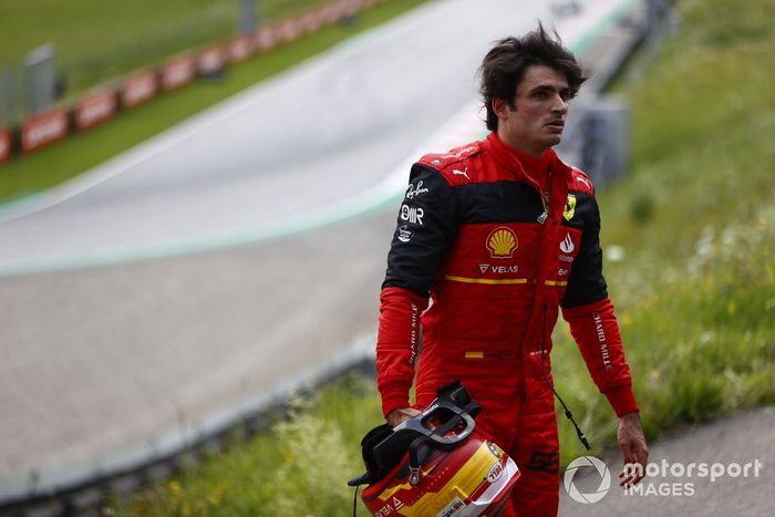 Carlos Sainz, de Ferrari, se aleja de su coche tras un incendio