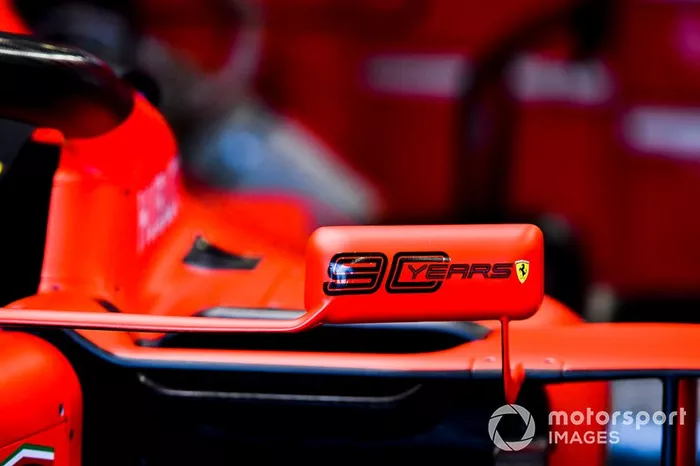 Logo de 90 años en el espejo de un Ferrari SF90.