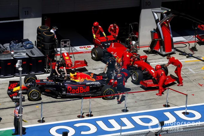 Mecánicos en el pit lane con los coches de Max Verstappen, Red Bull Racing RB16, y Sebastian Vettel, Ferrari SF1000