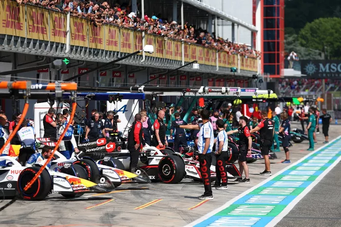 Los mecánicos guían a los pilotos hasta el pitlane
