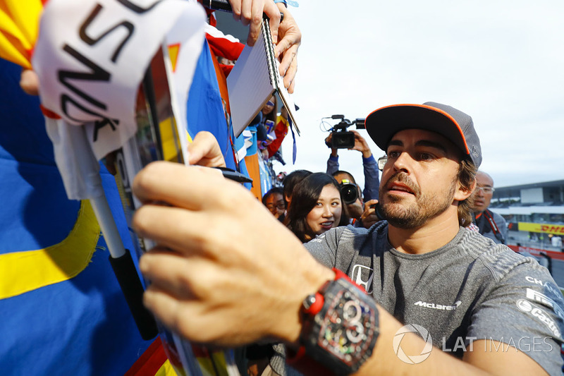 Fernando Alonso, McLaren, signs an autograph