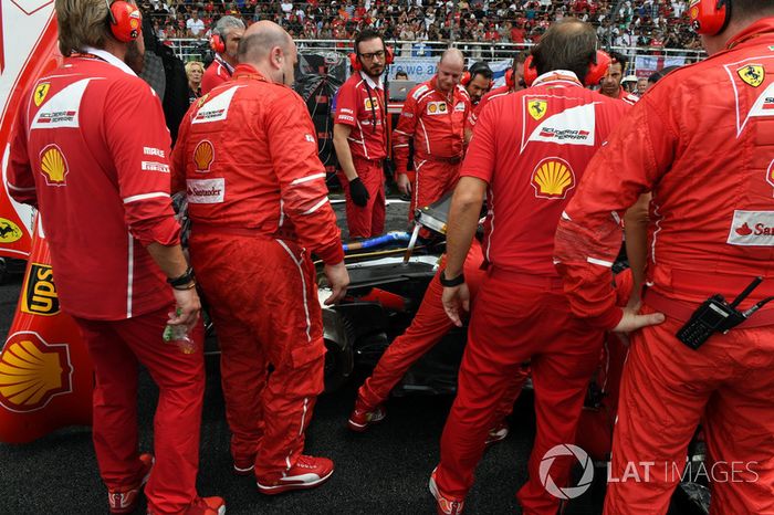 Ferrari mecánicos observan el coche de Kimi Raikkonen, Ferrari SF70-H con problemas de Turbo
