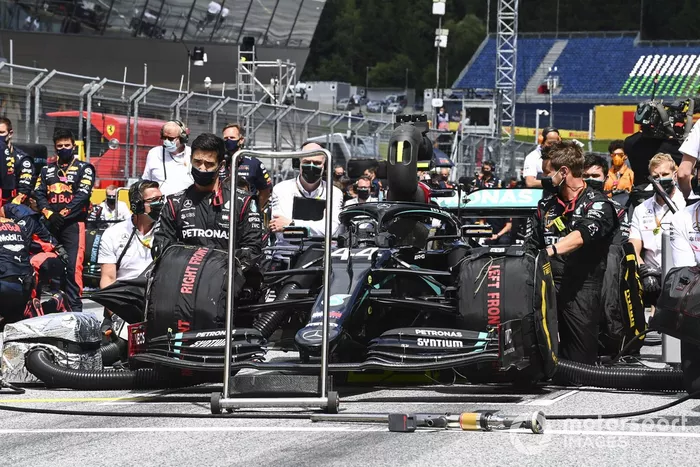 Los miembros del equipo Mercedes se arrodillan en la parrilla