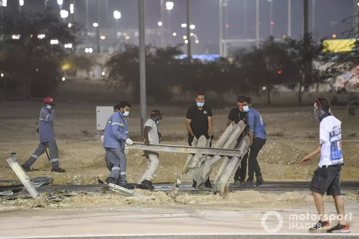 Los oficiales retiran los restos después del choque de Romain Grosjean, Haas VF-20, en la primera vuelta