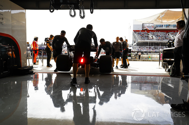 McLaren engineers return Fernando Alonso, McLaren MCL32, to the garage