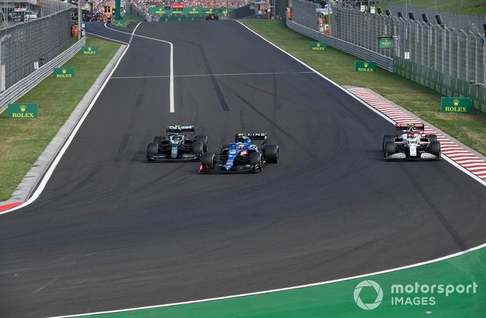 Esteban Ocon, Alpine A521, Sebastian Vettel, Aston Martin AMR21, mientras giran Antonio Giovinazzi, Alfa Romeo Racing C41