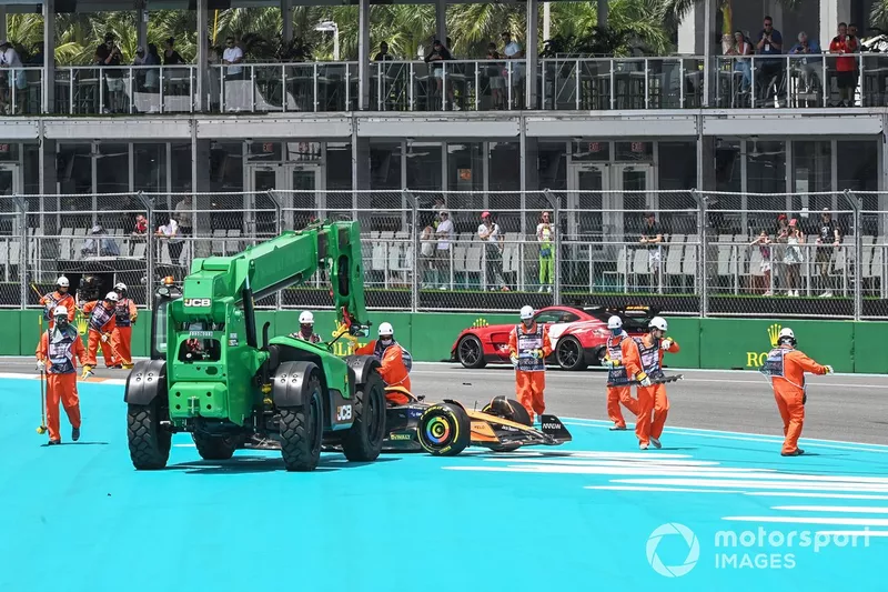 Les commissaires dégagent la voiture de Lando Norris, McLaren MCL38, après l'incident du premier tour.