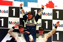 Jacques Villeneuve, Williams is lifted shoulder high by Mika Hakkinnen, McLaren and David Coulthard,