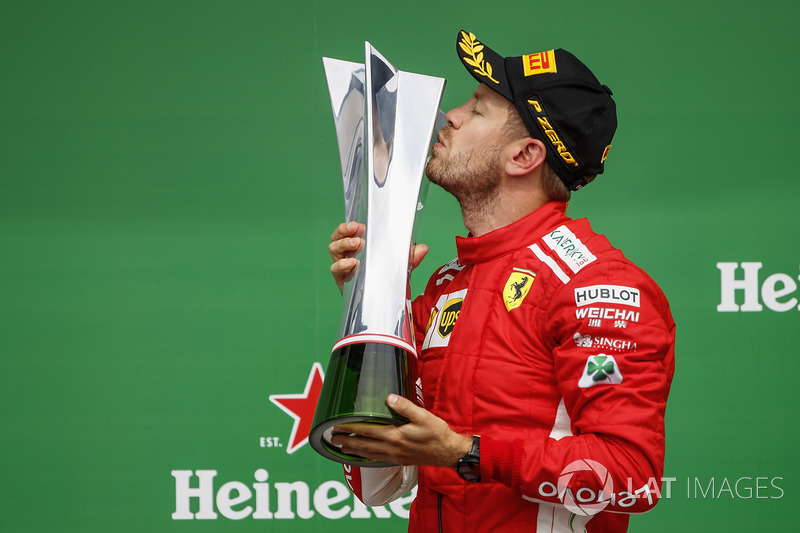Sebastian Vettel, Ferrari, 1st position, celebrates by kissing his trophy on the podium