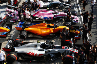 Cars of Kevin Magnussen, Haas F1 Team VF-18, Lando Norris, McLaren MCL33, Esteban Ocon, Racing Point Force India VJM11, and Lewis Hamilton, Mercedes AMG F1 W09, line up in the pit lane
