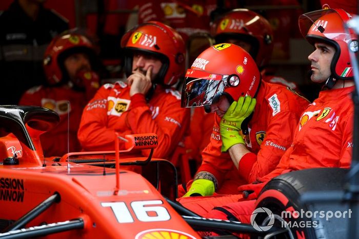 Meccanici seduti nel garage accanto alla monoposto del ritirato Charles Leclerc, Ferrari SF90 