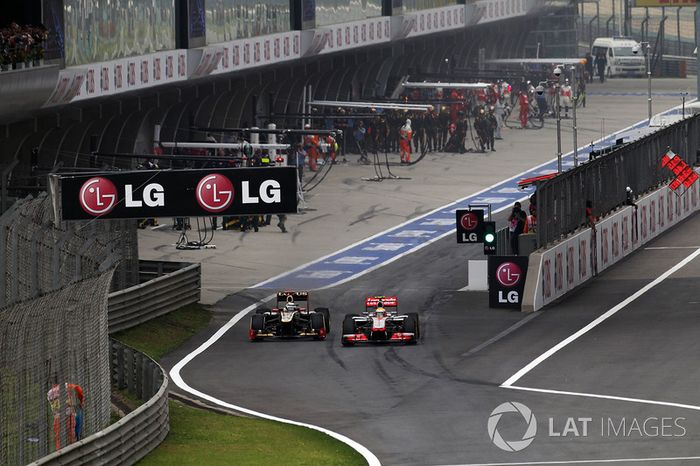 Kimi Raikkonen, Lotus E20 y Lewis Hamilton, McLaren MP4-27 batalla en pit lane