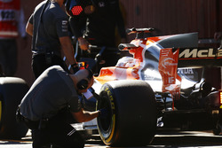 A Pirelli engineer checks a tyre on the Fernando Alonso McLaren MCL32