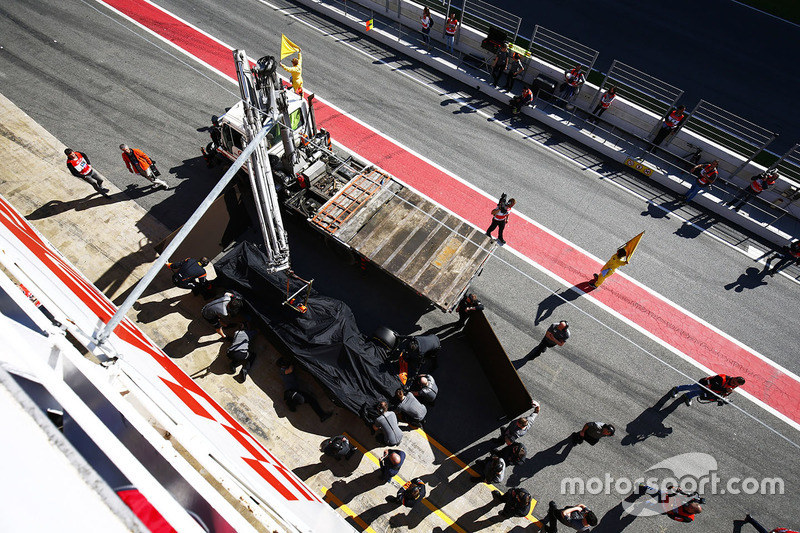 The McLaren MCL32 of Fernando Alonso is returned to the pits on a truck