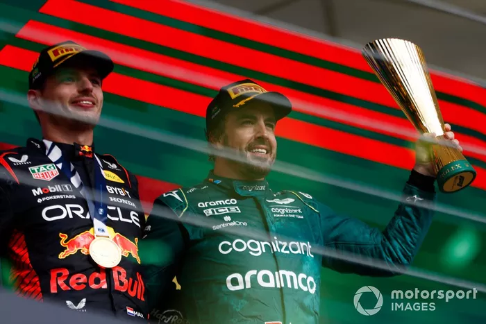 Fernando Alonso, Aston Martin F1 Team, 3ª posición, levanta su trofeo en señal de celebración junto a Max Verstappen, Red Bull Racing, 1ª posición.
