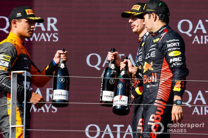 Lando Norris, McLaren, 2ª posición, Max Verstappen, Red Bull Racing, 1ª posición, Sergio Pérez, Red Bull Racing, 3ª posición, en el podio con Champagne.