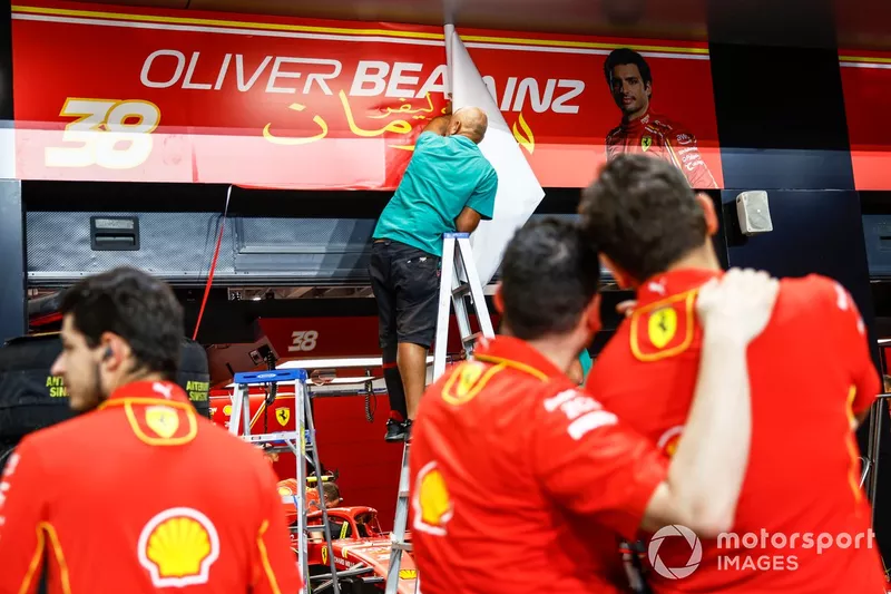 Le personnel du circuit remplace la bannière du garage de Carlos Sainz, Scuderia Ferrari, par celle d'Oliver Bearman, Scuderia Ferrari.