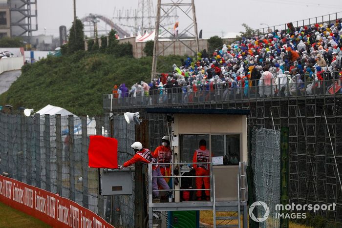 Oficiales de pista ondean la bandera roja