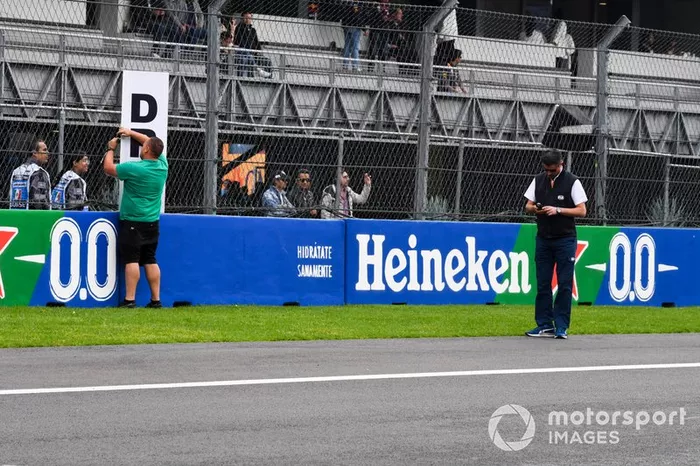 Michael Masi, Director de Carrera de la FIA, ayuda con la instalación de la señalización de zona DRS