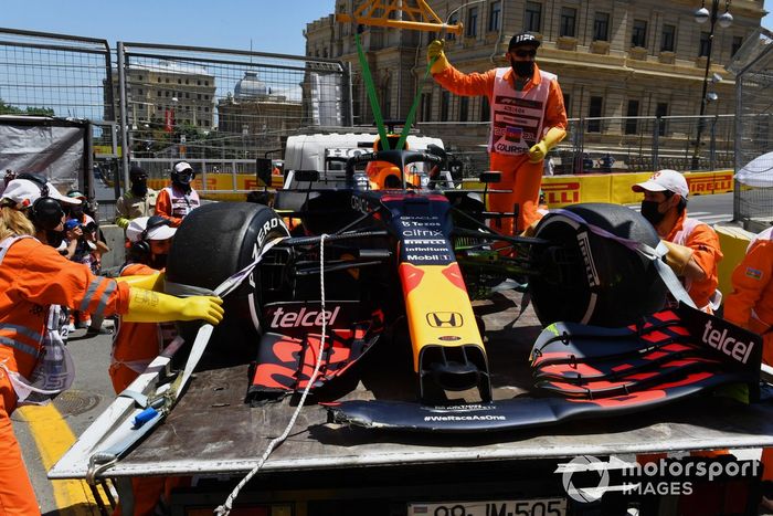 Los comisarios carga en coche dañado de Max Verstappen, Red Bull Racing RB16B, en una grúa