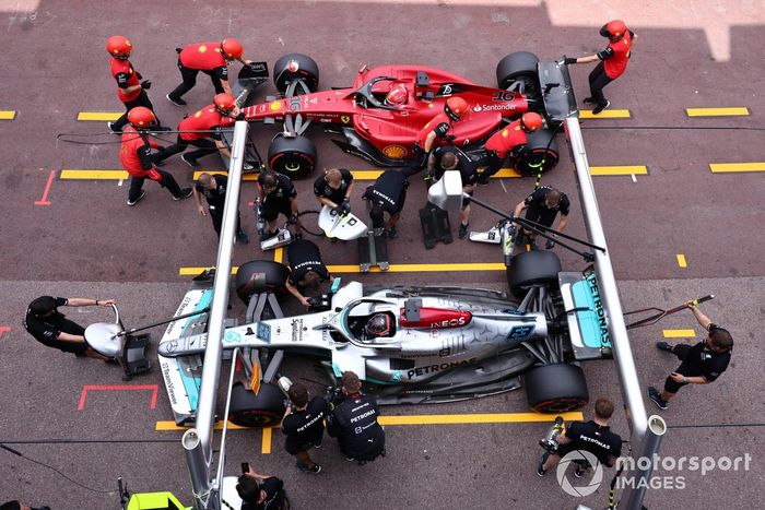 George Russell, Mercedes W13, Charles Leclerc, Ferrari F1-75, en el pit lane