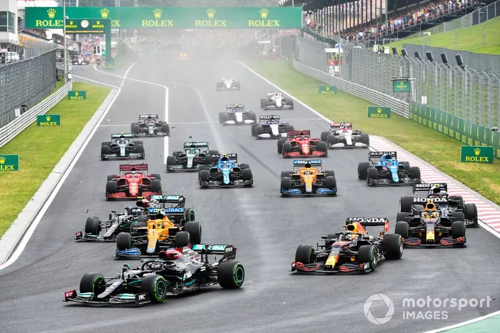 Lewis Hamilton, Mercedes W12, Max Verstappen, Red Bull Racing RB16B, y Sergio Pérez, Red Bull Racing RB16B, mientras Valtteri Bottas, Mercedes W12, choca con Lando Norris, McLaren MCL35M.