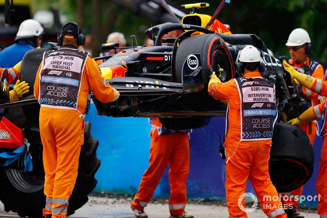 Los comisarios retiran el coche dañado de Sergio Pérez, Red Bull Racing RB20