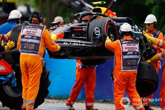 Los comisarios retiran el coche dañado de Sergio Pérez, Red Bull Racing RB20