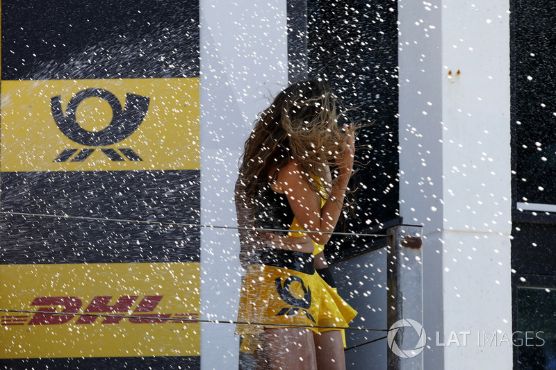 Podio: doccia con lo champagne per una grid girl