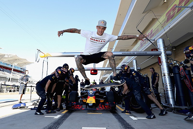 Skateboarder Ryan Sheckler performs a trick in front of the Red Bull Racing team