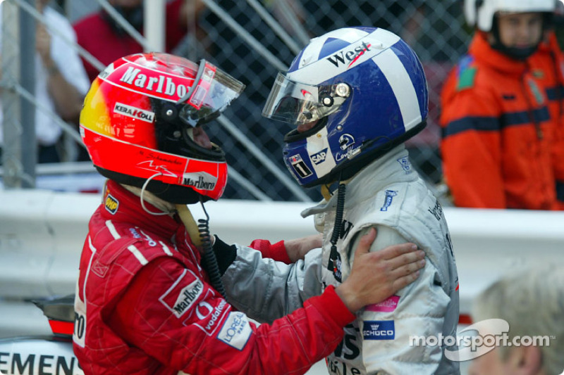 Michael Schumacher felicitaando al ganador de la carrera, David Coulthard