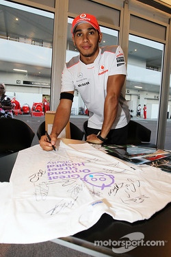 Lewis Hamilton, McLaren Mercedes, signs memorabilia for Great Ormond Street Hospital charity