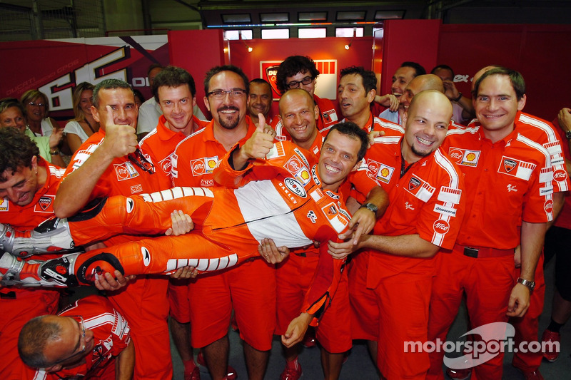 Race winner Loris Capirossi celebrates with Ducati team members