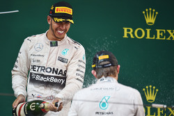 Победитель гонки Льюис Хэмилтон Mercedes AMG F1 празднует на подиуме с Нико Росбергом Mercedes AMG F