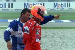 Michael Schumacher, Ferrari, retorna a pé para os boxes após acidente na largada