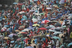 Ventilateurs avec des parapluies sous la pluie
